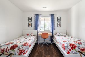 een slaapkamer met twee bedden, een bureau en een raam bij Canyon View Oasis home in Redlands