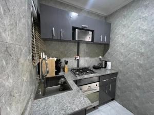 una cocina con estufa y encimera en Spacious one bed self compound, en Iju Junction