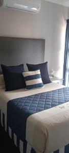 a bedroom with a bed with blue and white pillows at 68Warren in Vryburg