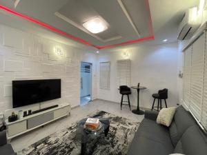 a living room with a couch and a flat screen tv at Spacious one bed self compound in Iju Junction