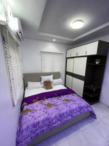 a bedroom with a large bed with purple sheets at Spacious one bed self compound in Iju Junction +28 photos