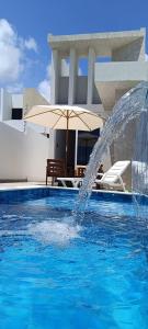 コンデにあるCasa de Praia com Piscina Coqueirinho João Pessoaの家の前の噴水付きプール