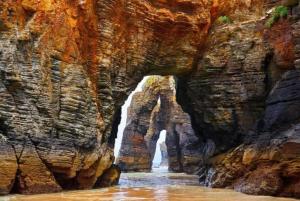 a canyon with a waterfall in the middle of it at Amanecer en Playa de LLás in Foz