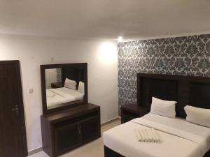 Giường trong phòng chung tại Ndameka Apartments