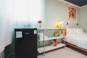 a room with a refrigerator next to a bed at Incheon 레토하우스 in Incheon