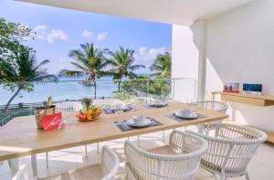 a dining room with a table and chairs with a view of the ocean at Les Estivales Beachfront Suites & Penthouses by LOV Mauritius in Trou aux Biches