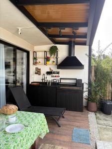 a patio with a table and a kitchen at Casa Malu in Bertioga
