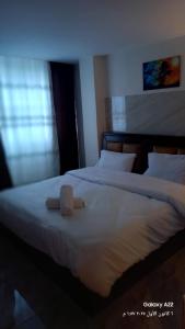 Un dormitorio con dos camas con sábanas y almohadas blancas. en Kahraman Amman Hotel, en Amán 3 fotos más