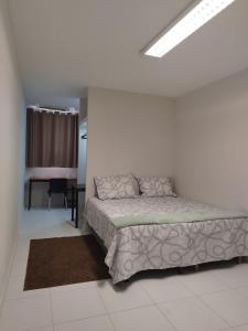 Un dormitorio con una cama en una habitación blanca. en Smart Malls Mundurucus 1427 batista campos, en Belém