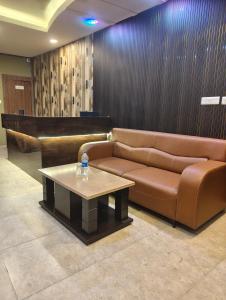 eine Lobby mit einem Sofa und einem Couchtisch in der Unterkunft Hotel Ardent in Ranchi