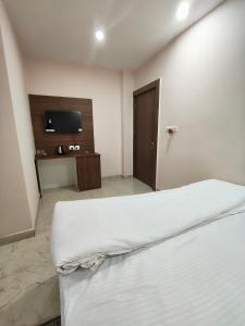 ein Hotelzimmer mit Bett und Fernseher in der Unterkunft Hotel Ardent in Ranchi