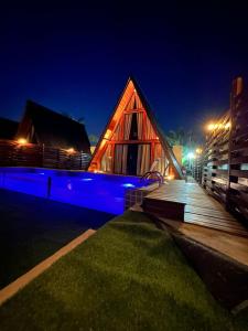 una casa di legno con luci blu di notte di LIMMAT Chalés a Hora