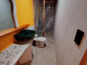Homestay Natural Paradise habitación 3 في سان كريستوبال: حمام مع حوض أخضر ومرحاض +22 صورة