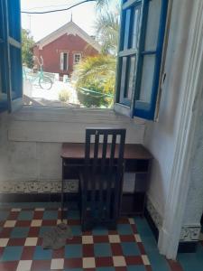 a chair sitting in front of a window with a table at Paloma in Atlántida