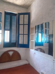 a room with blue shuttered windows and a bench at Paloma in Atlántida