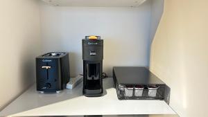 eine Kaffeemaschine und eine Kiste auf einem Regal in der Unterkunft Ocean and Mountain View Home - Downtown Vancouver in Vancouver