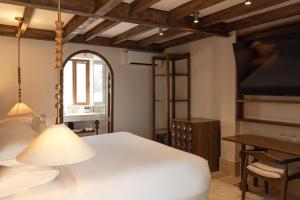 een slaapkamer met een wit bed en een bureau bij Hotel Palacio del Agua by Faranda Boutique in Cartagena