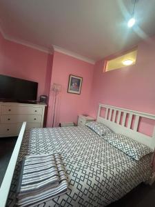 a bedroom with a bed and a dresser and a tv at Paignton seafront Apartment with Private Garden ,FREE Private Car Space FREE WIFI ,No kitchen but Fridge Tea coffee Towels YES Double & Single bed YES Reception to help you YES Opposite the Beach Yes in Paignton