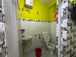 a small bathroom with a toilet and a sink at Jagannath Guest House in Navadwīp