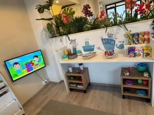 a room with a tv and a shelf with plants at Hotel Bel Sito Peschiera in Peschiera del Garda