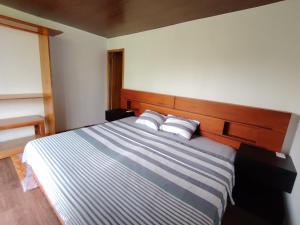 Homestay Natural Paradise habitación 3 في سان كريستوبال: غرفة نوم بسرير مخطط ازرق وابيض مع وسادتين