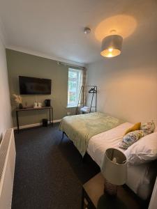 Stylish Private Rooms في بيرجس هيل: غرفة نوم بسريرين وطاولة وتلفزيون