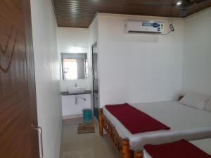 una piccola camera da letto con un letto e un lavandino di Gokarna Beach Near Homestay a Gokarna Altre 4 foto