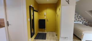 Votre Refuge Urbain Logement Complet pour Étudiants et Pros في فوجير: ممر به سرير وجدار أصفر +7 صور