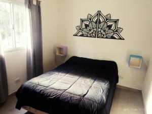 a bedroom with a bed and a picture on the wall at Sal y Arena in Colonia Chapadmalal