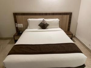 a bedroom with a large bed with white sheets and pillows at RG Hotels and Resort in Mālūr +11 photos