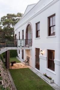 a white house with a cat sitting in the yard at Mountain and Tides in Kleinmond