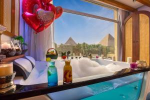 een badkamer met bad met uitzicht op de piramides bij Pyramids Vision Hotel in Caïro