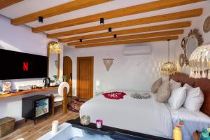 een slaapkamer met een wit bed en een tv bij Pyramids Vision Hotel in Caïro