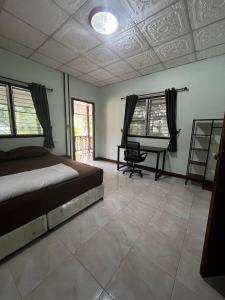 Un dormitorio con una cama y un escritorio. en Lotus Garden House, en Ko Pha Ngan