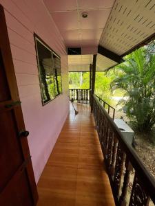 un porche de una casa con una pasarela de madera en Lotus Garden House, en Ko Pha Ngan 7 fotos más