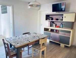 a dining room with a table and a tv at Casa Marisa - facing campo in Murano - Venezia in Murano