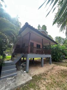 Una pequeña casa con porche y escaleras. en Lotus Garden House, en Ko Pha Ngan