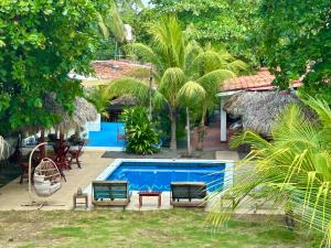 a resort with a swimming pool and palm trees at Hotel Tranquilo in Las Peñitas +91 photos