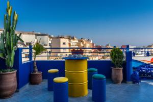 een balkon met potplanten en uitzicht op de stad bij Nomazigh Surf House in Tamraght Ouzdar