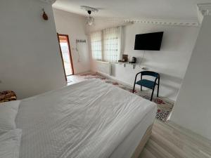 a bedroom with a white bed and a blue chair at Gumus Hotel in Ortahisar
