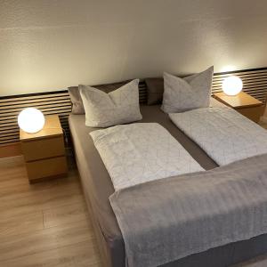 En eller flere senge i et værelse på Ferienwohnung Waldhöhe -sonniger Balkon-Boxspringbett-Ladestation E-Auto