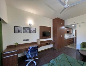 een slaapkamer met een bed, een bureau en een tv bij luxury stay in Dehradun