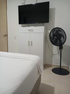 Jardin imperial, habitaciones para tu disfrute y descanso en apto familiar في كارتاهينا دي اندياس: غرفة بها سرير ومروحة وتلفزيون بشاشة مسطحة +7 صور