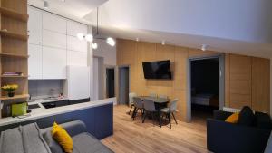 a living room and kitchen with a couch and a table at 4-Bedroom Luxury Apartment in New Gudauri in Gudauri