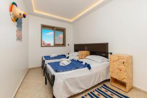 een slaapkamer met twee bedden en een schilderij aan de muur bij Nomazigh Surf House in Tamraght Ouzdar +55 foto's