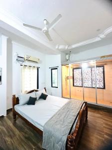 a bedroom with a bed and a ceiling fan at SALT beach resort classic in Kālapettai