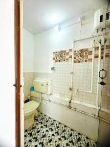 a bathroom with a toilet and a tiled floor at SALT beach resort classic in Kālapettai +36 photos