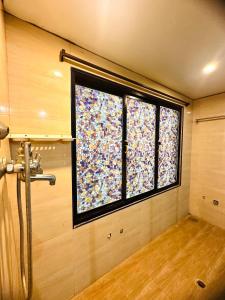 a bathroom with a shower and a window with confetti at SALT beach resort classic in Kālapettai