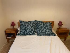 a bed with two pillows on it with two night stands at Vue SUR VIADUC DE MILLAU in Millau
