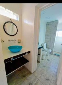 a bathroom with a blue sink and a toilet at Atardeceres del dique in Cortaderas